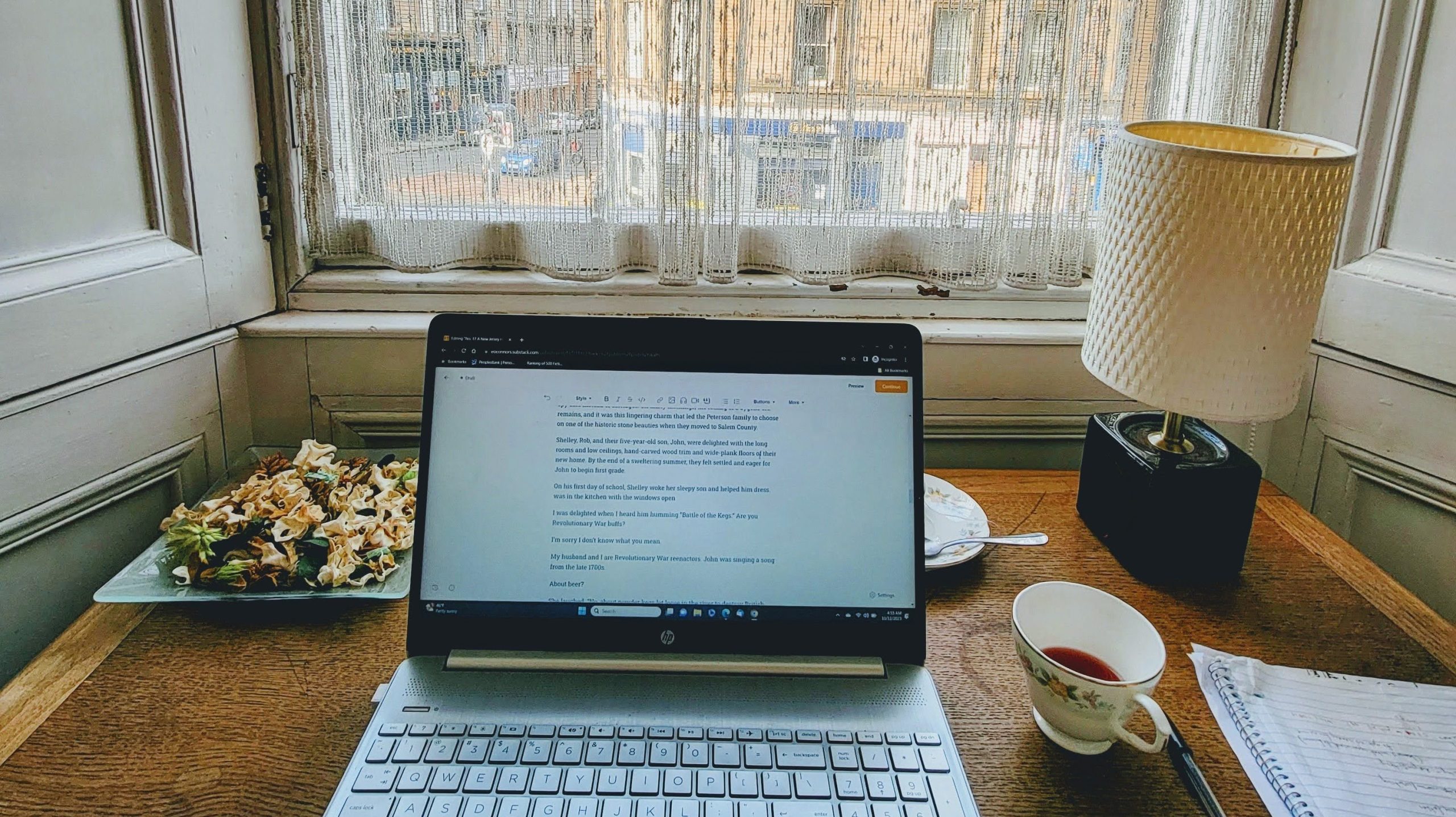 Laptop on a desk with a cup of tea